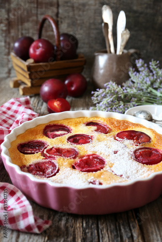 Red plums clafoutis (flan), icing sugar dressing, french cuisine