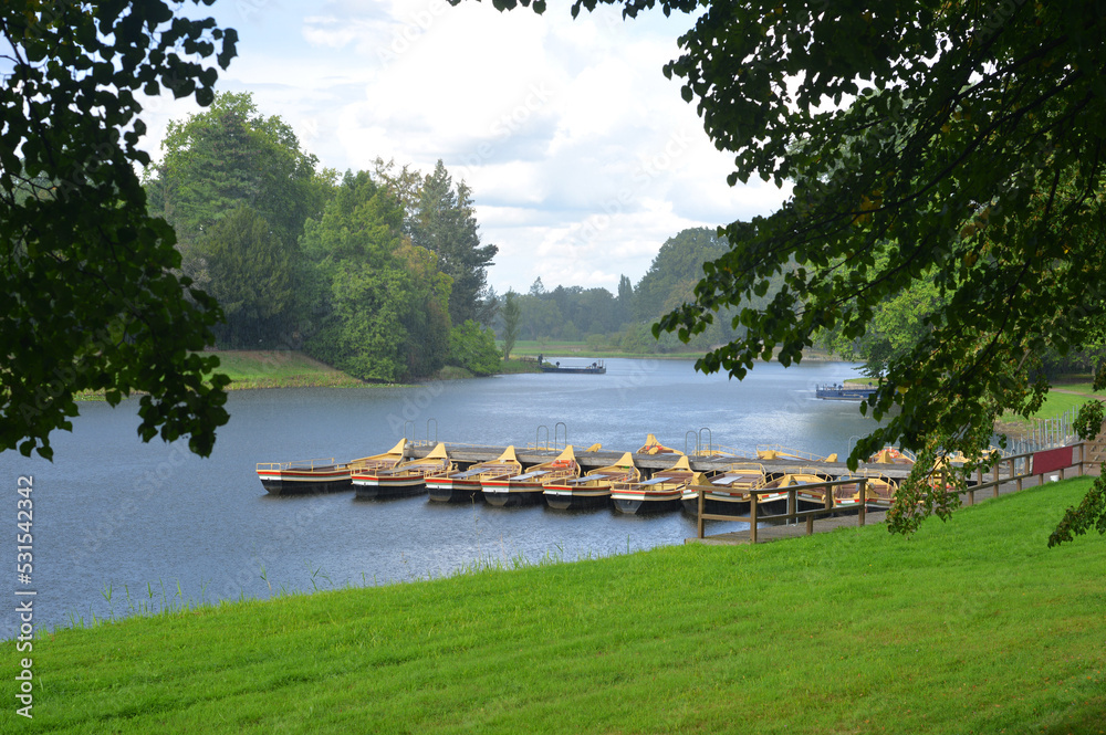 Naklejka premium Woerlitz, Park and Garden Landscape with boats and vintage ferrys under a short summer rain