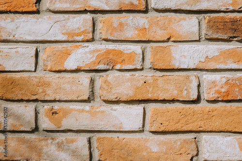 Texture, background of brown, orange bricks on the wall in spots. Close-up photography, architecture.