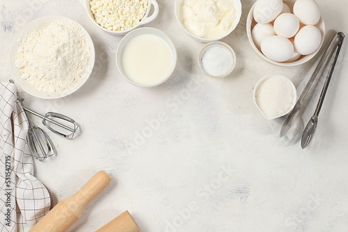 Frame for baking and making cake, bread, confectionery and ingredients for cooking, milk, flour, salt, sugar, eggs and cream on a concrete background with space for text, selective focus,