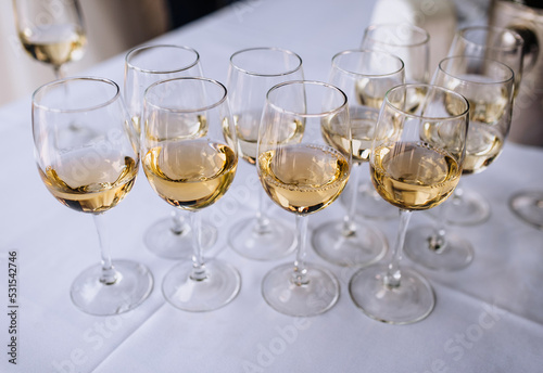 A lot, a row of glass glasses with champagne stands on a table in a bar, restaurant. Photography, party.