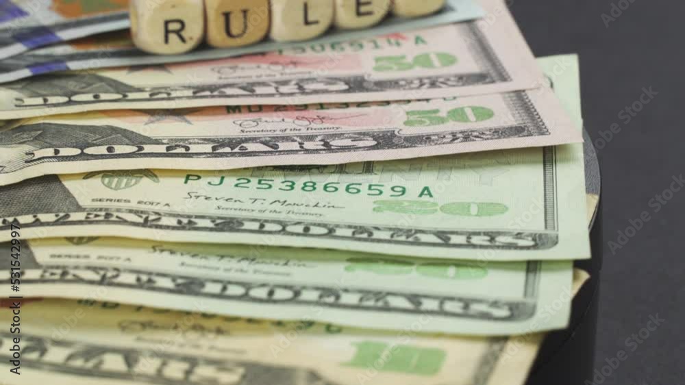 Business concept. Dollar banknotes and cubes with the inscription - rules,lie on a platform rotating clockwise. Close-up Business concept. Dollar banknotes and cubes with the inscription - rules,lie on a platform rotating clockwise. Close-up