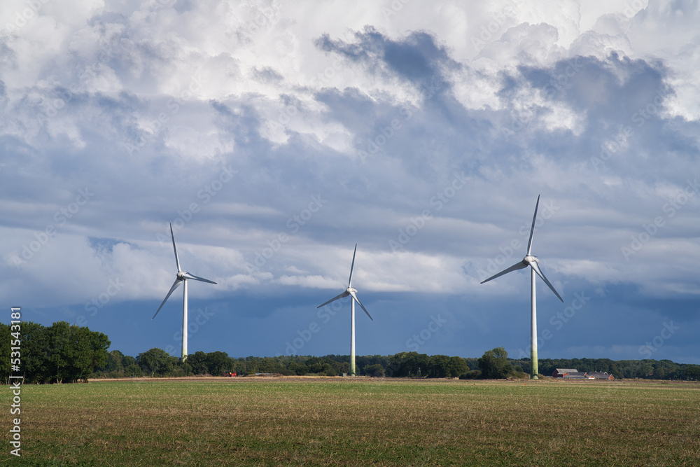 Wind turbines with dramatic sky before a storm on the countryside in Skane, Sweden. Wind turbines with dramatic sky before a storm on the countryside in Skane, Sweden.