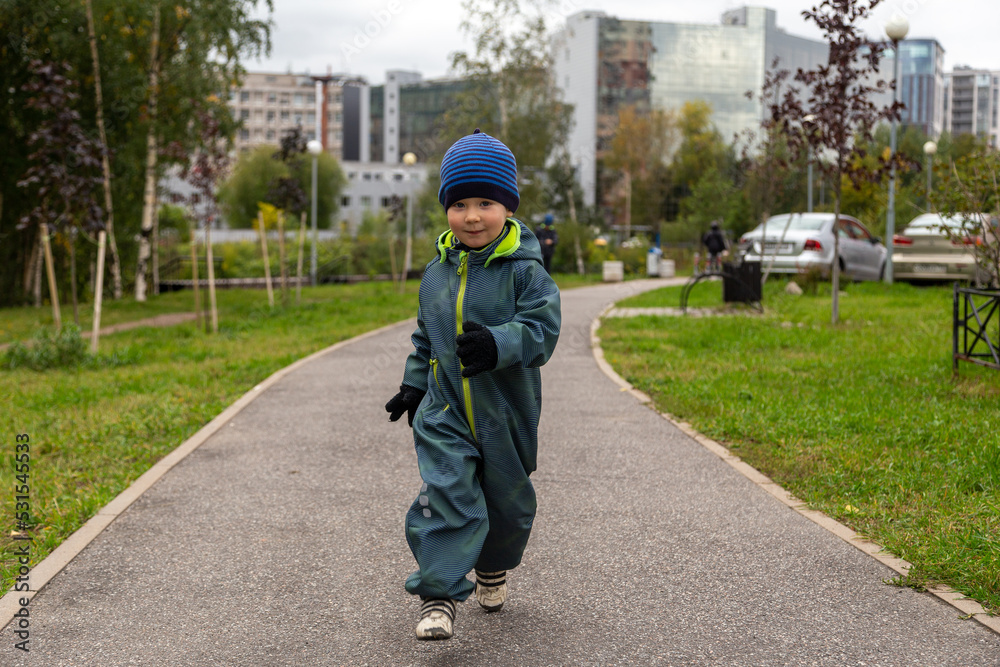 a two-year-old toddler boy runs along the path in the park near the house on the street in autumn in a hat and overalls. Joyful and happy baby
a two-year-old toddler boy runs along the path in the park near the house on the street in autumn in a hat and overalls. Joyful and happy baby