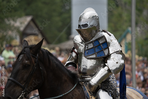 unknown knight in a suit of armor is riding on a horse and ready for battle © J.A.