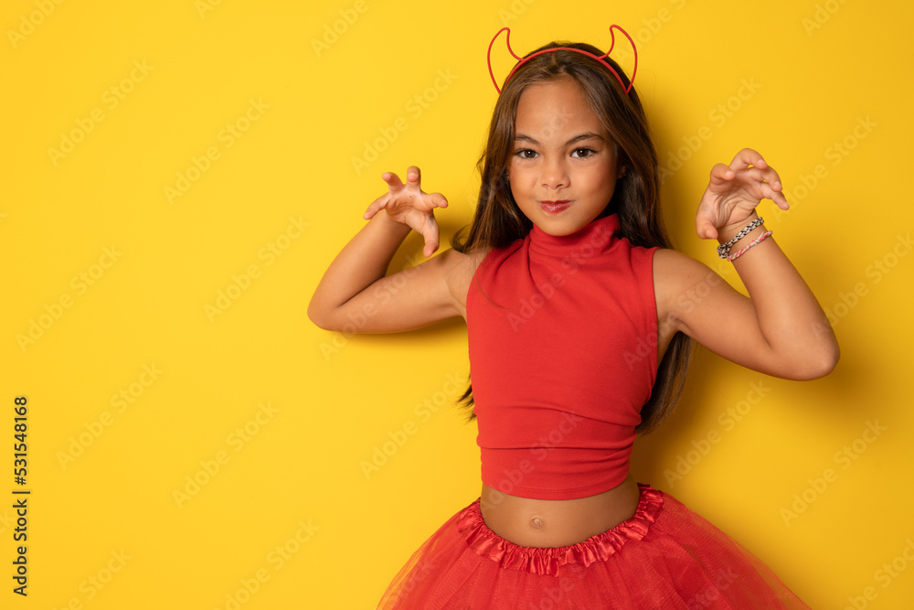 Portrait of an angry little girl in a costume, on a yellow background. halloween. Portrait of an angry little girl in a costume, on a yellow background. halloween.