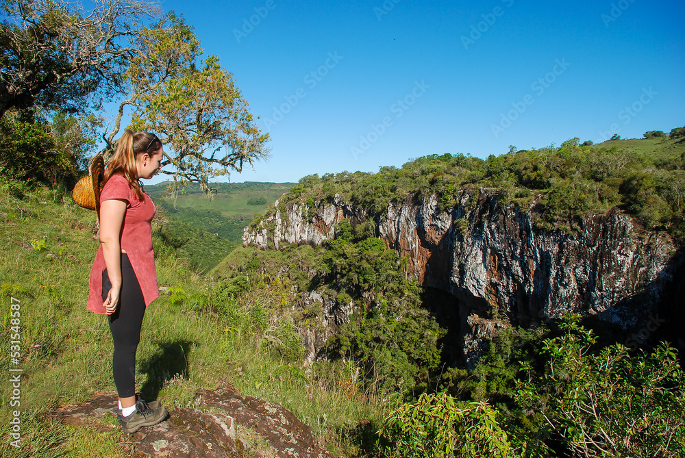 Naklejka premium Woman contemplating the view at Palanquinhos Canyon in Caxias do Sul, Rio Grande do Sul, Brazil
