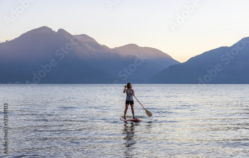 Adventurous Woman Paddling on a Paddle Board in a peaceful lake. © edb3_16