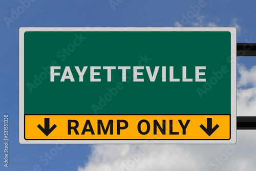 Fayetteville logo. Fayetteville lettering on a road sign. Signpost at entrance to Fayetteville, USA. Green pointer in American style. Road sign in the United States of America. Sky in background