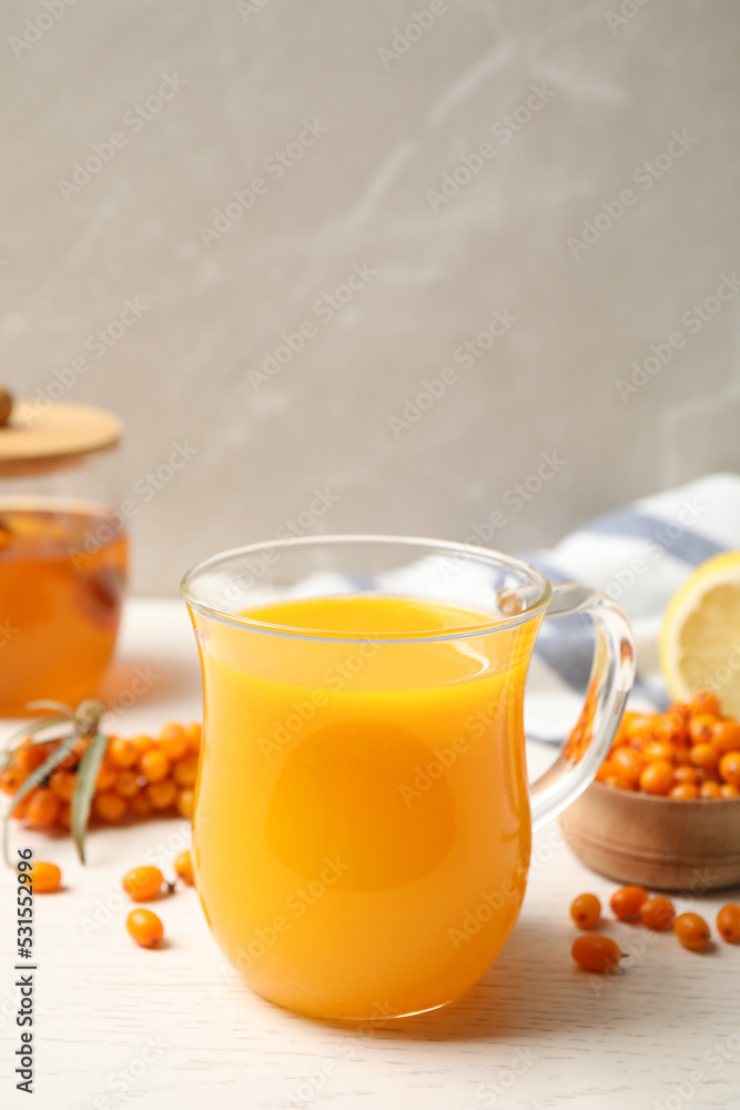 Fresh sea buckthorn tea on white wooden table Fresh sea buckthorn tea on white wooden table