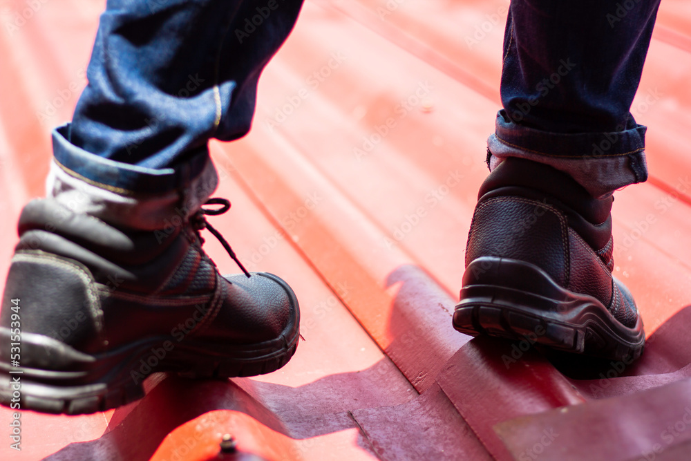 Wear safety shoes to ensure safety at work. construction workers wear safety shoes. concept working at height