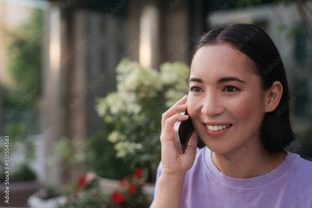 Portrait of smiling asian woman talking on mobile phone looking away, copy space Portrait of smiling asian woman talking on mobile phone looking away, copy space