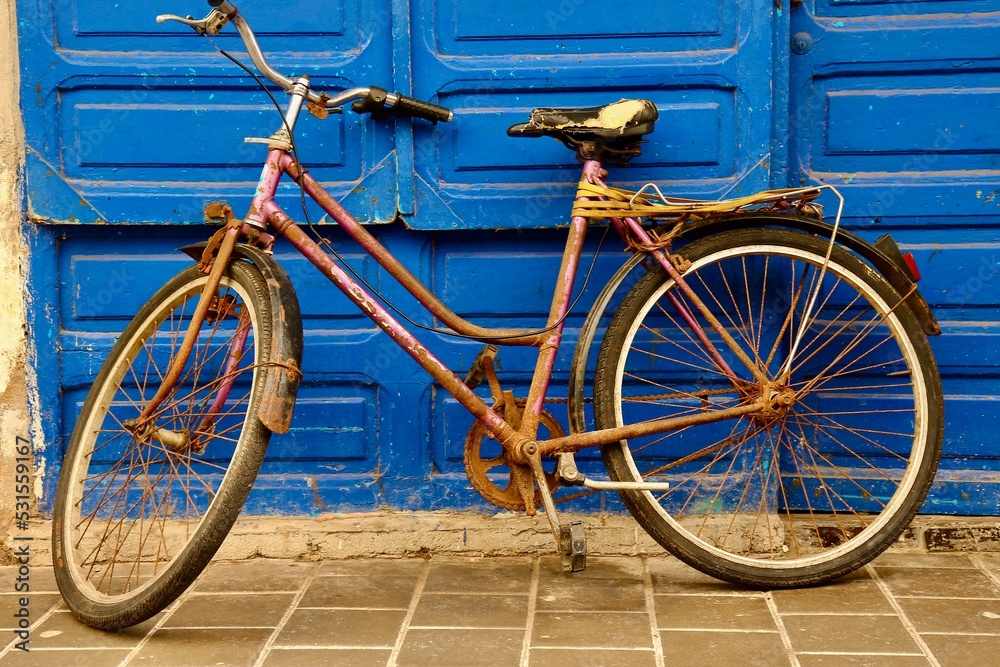 Old rustic bicycle on the blue door background 
