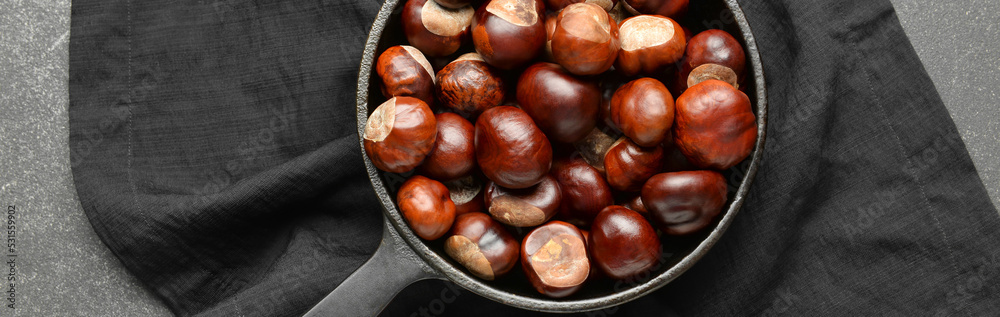 Frying pan with chestnuts on dark background, top view Frying pan with chestnuts on dark background, top view