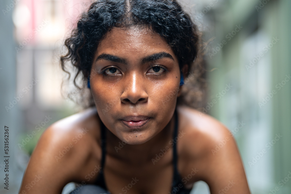 Portrait of a female athlete on a black background. Woman sprinter