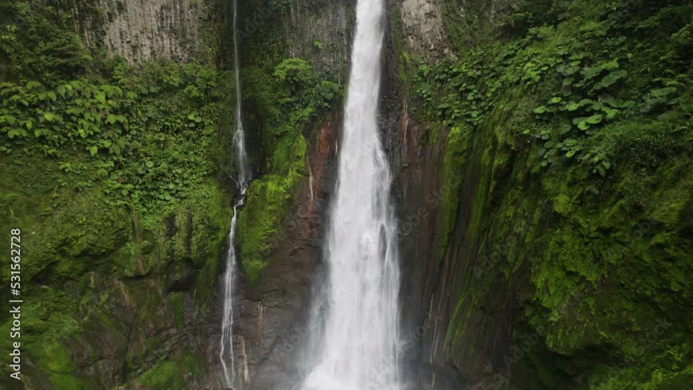 Aerial tilt up reveals two falls in jungle plummeting over cliff edge Aerial tilt up reveals two falls in jungle plummeting over cliff edge
