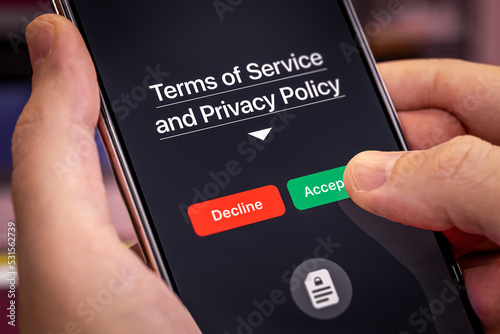 Smartphone user agrees to accept Terms of Service and Privacy Policy mobile app. Finger touches the Accept button. Dark app interface with Accept and Decline buttons photo