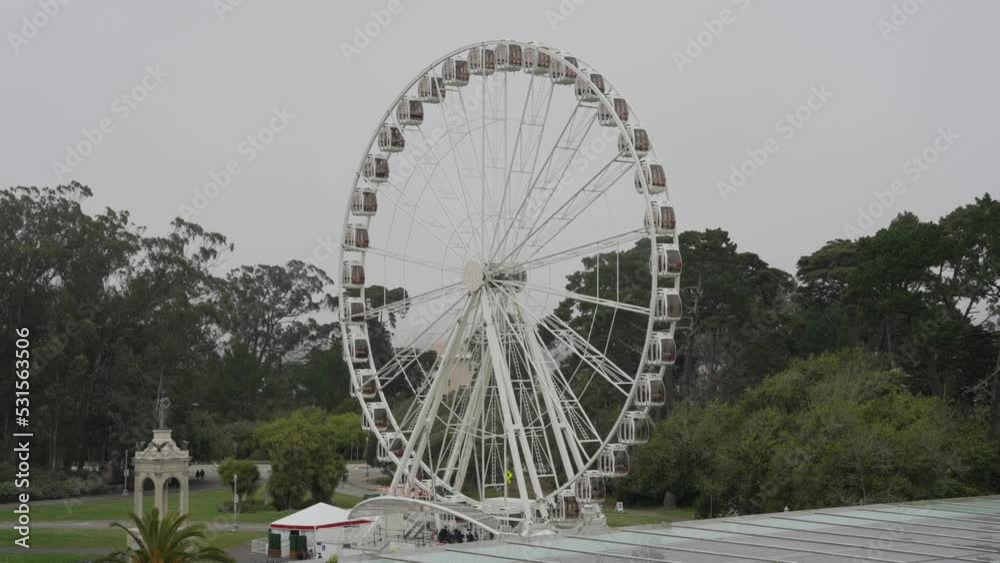 This video shows a large outdoor ferris wheel with overcast skies in the background. This video shows a large outdoor ferris wheel with overcast skies in the background.