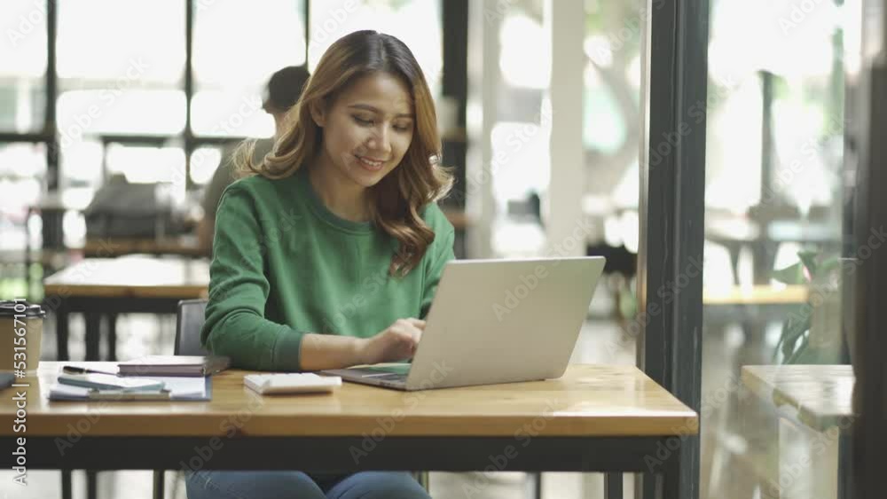 Asian woman working in a coffee shop with laptop online work concept Asian woman working in a coffee shop with laptop online work concept