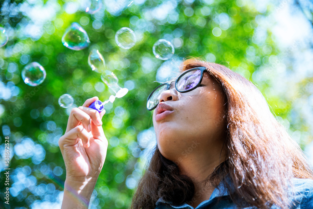 Happiness woman blowing soap joyful outdoors green park. Asian young women joy blow bubble leisure freedom lifestyle. Gorgeous girl enjoying relaxation person. beautiful female play with happy face