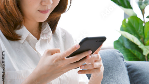 Asian woman holding smartphone with E-commerce Shopping online website Reading Online Article, Blog, vlog. Young Woman hands holding phone technology lifestyle. Happy Woman using digital smart phone