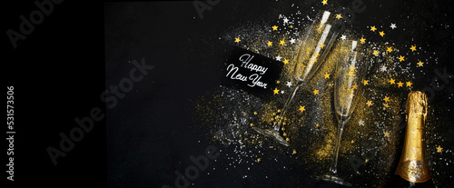 Fototapeta Naklejka Na Ścianę i Meble -  Glass of champagne and bottle on dark background.
