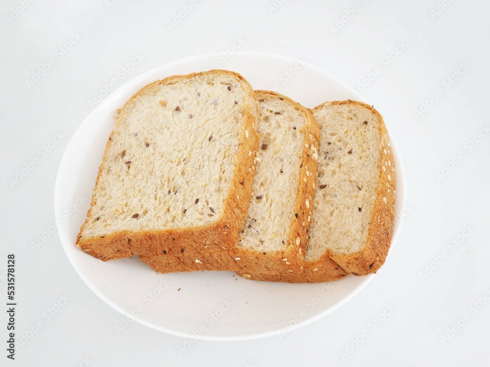Whole grain bread on a white plate. Closeup photo, blurred. Whole grain bread on a white plate. Closeup photo, blurred.