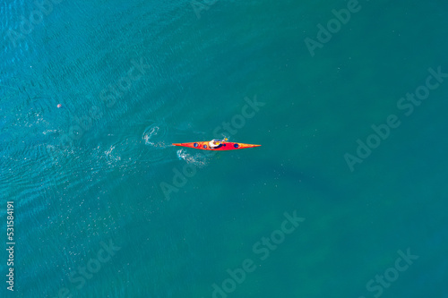 Red kayak boat blue turquoise water sea, sunny day. Concept banner travel, aerial top view