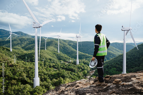 Young maintenance engineer man working in wind turbine on the mountain photo