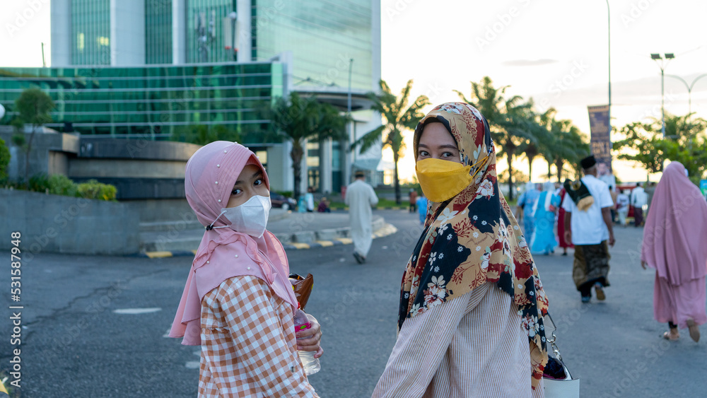 Obraz premium mother and daughter take a photo together after celebrating Eid al-Fitr