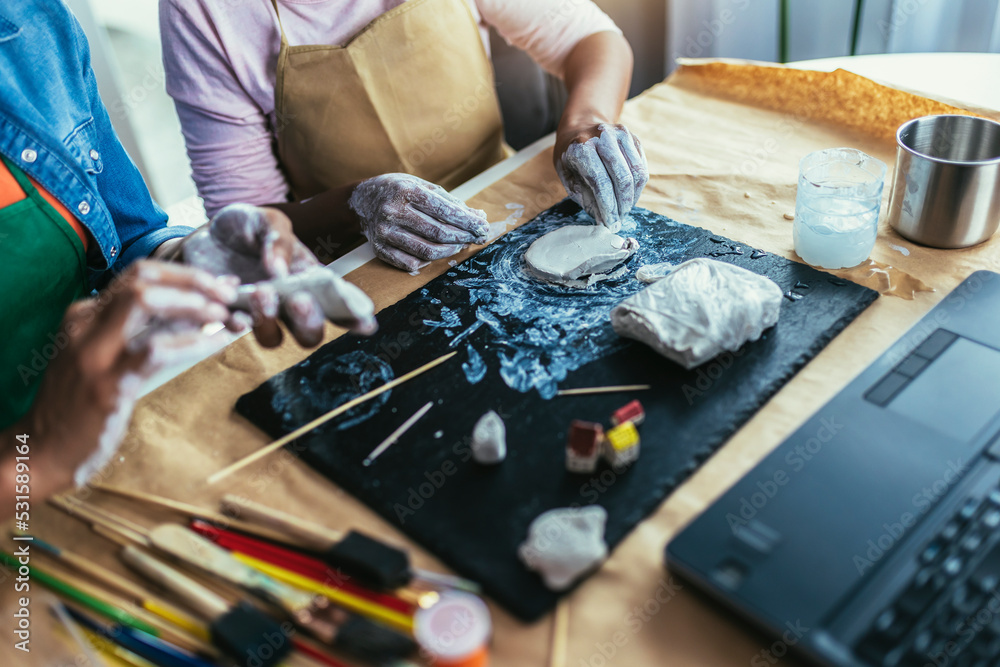Fototapeta premium Mother and daughter spend time together and sculpting from clay at home
