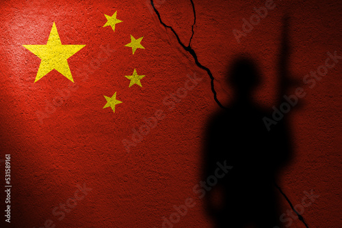 Flag of China painted on a cracked wall with soldier shadow photo