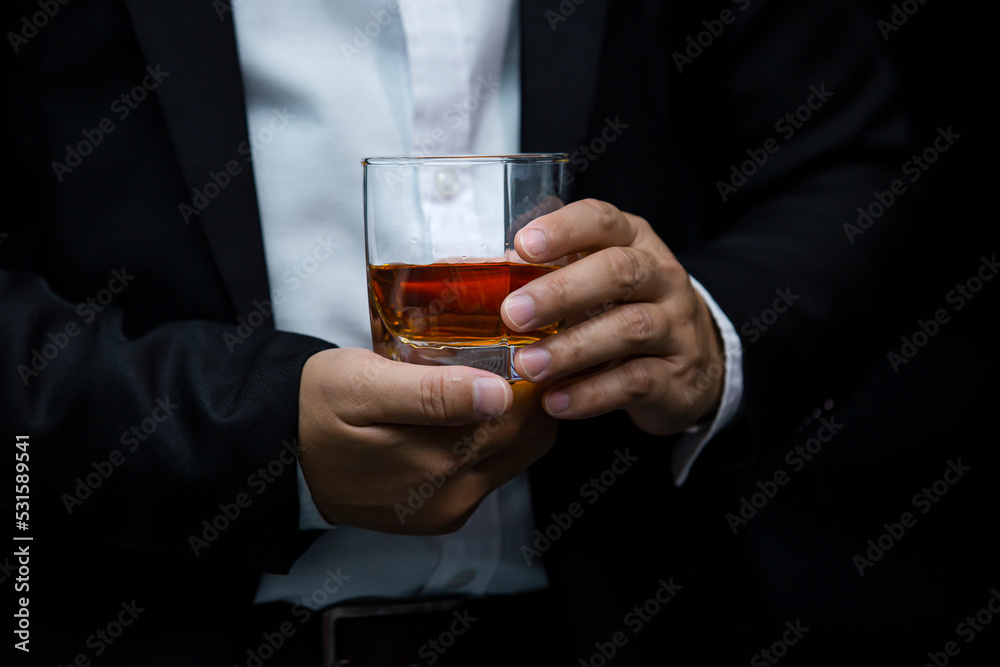 Closeup businessmen holding a glass of whiskey Closeup businessmen holding a glass of whiskey