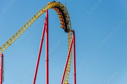 Roller coaster against the blue sky. Amusement park with attractions.