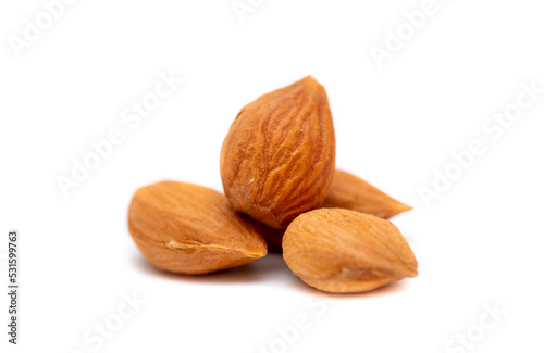 Apricot kernels peeled close-up as a background. Apricot grains heap isolated on white background.
