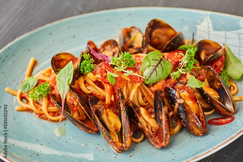 Pasta with mussels with red sauce. Food from the chef in a restaurant or cafe. Pasta with mussels with red sauce. Food from the chef in a restaurant or cafe.