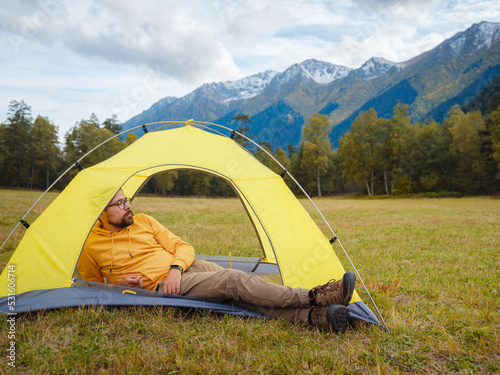 trip to Caucasus mountains, Arkhyz, Teberdinsky reserve. Man traveler relaxing in mountains in tent camping outdoor Travel adventure lifestyle concept hiking active vacations.