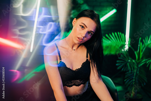 Beautiful woman portrait in neon light with bright colorful makeup. Club night style