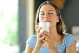 Young woman smelling coffee from cup in a restaurant