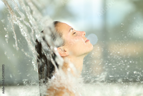 Woman under water jet in spa breathing