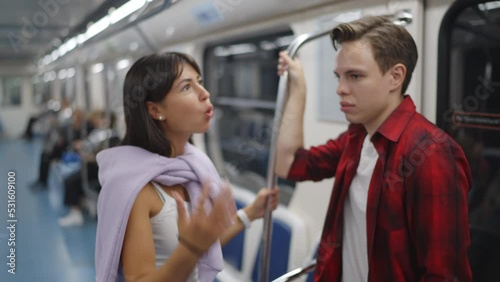 A couple rides on the subway, stand, hold on to the handrail, swear, talk, shout. Slow motion 120fps footage