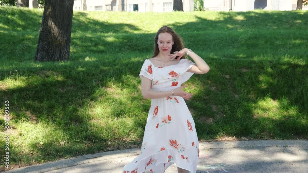 Amazing young female dancer in a summer dress dancing in the park Amazing young female dancer in a summer dress dancing in the park