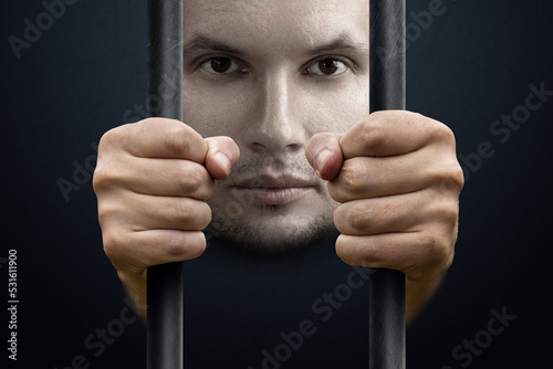 Stress, depression, emotional burnout. The face and hands of a man behind bars. Pessimism, loneliness, problems, unhappy person. Modern design, magazine style.