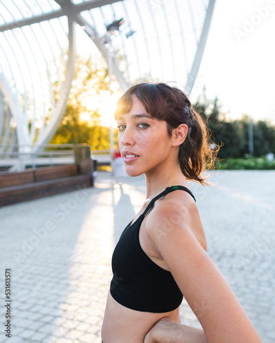 Young woman with hair bangs at footpath on sunny day photo