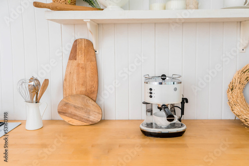 Modern coffee machine with cup on counter in kitchen