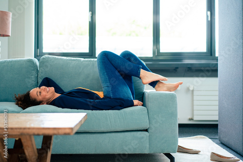 Smiling businesswoman relaxing on sofa in break time at office photo