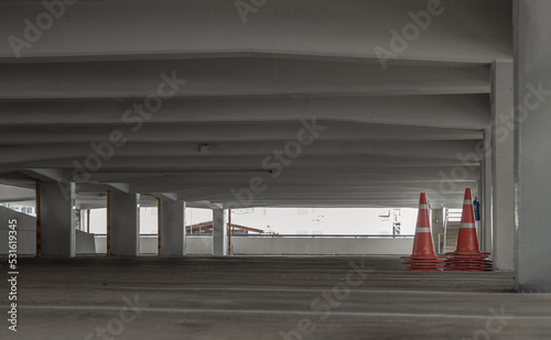 Bangkok, Thailand - 10 Sep 2022 : Orange traffic cones in parking lot building. Perspective view of carpark area with traffic cones in the afternoon, Space for text, Selective focus.