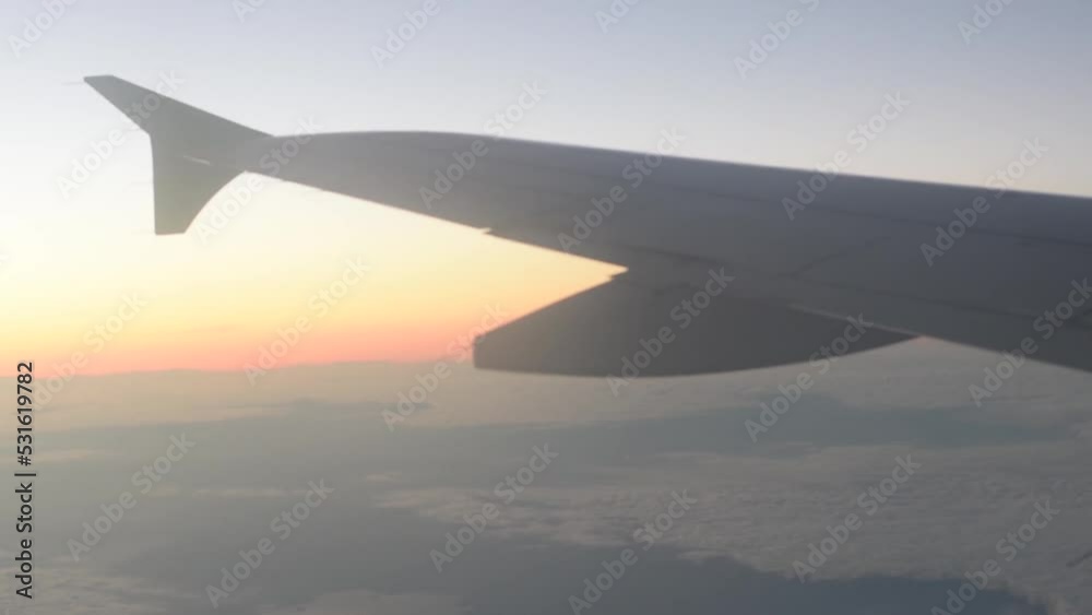 vista desde la ventanilla de un avion de aerolinea del horizonte en el ocaso con el ala del avion desenfocada
