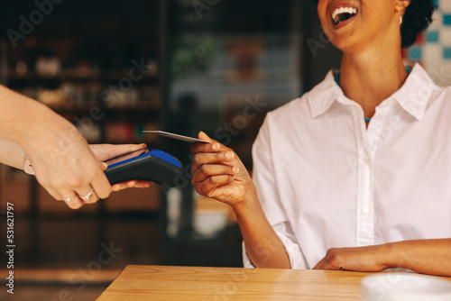 Happy customer paying her bill using a credit card photo