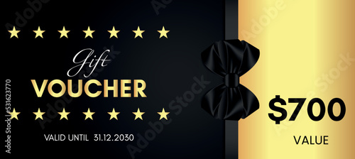 700 Dollar value gift voucher template design with black bow and gold star isolated on black background. Special offer gift voucher template to save money. Gift certificates, tickets, coupon code.